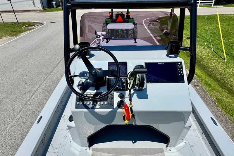 Slide: The Image of 2022 Majek 24 Reaper boat dashboard with steering wheel and navigation controls. - 10