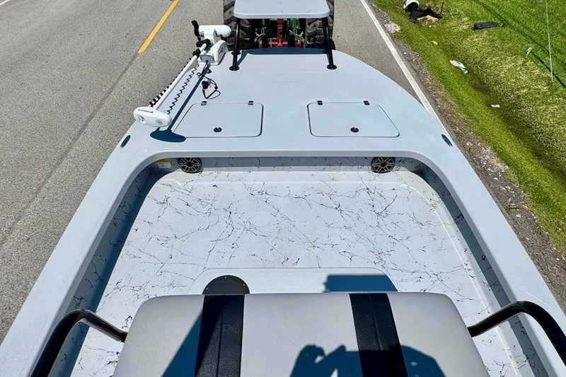 Slide: The Image of 2022 Majek 24 Reaper boat on road, featuring spacious deck and trolling motor. - 12