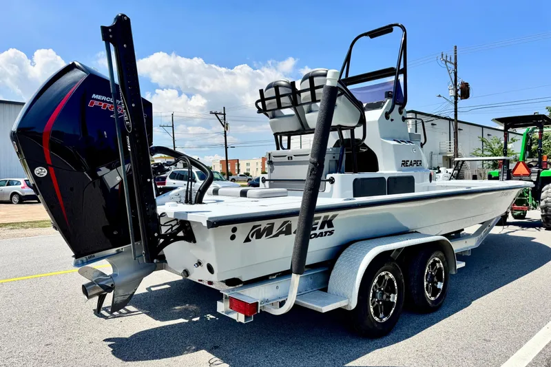 Slide: The Image of 2022 Majek 24 Reaper boat on trailer, featuring Mercury Pro XS engine, parked outdoors. - 4