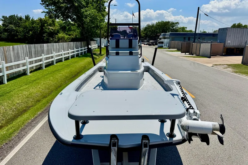Slide: The Image of 2022 Majek 24 Reaper boat on road, sunny day, green grass, white fence. - 6
