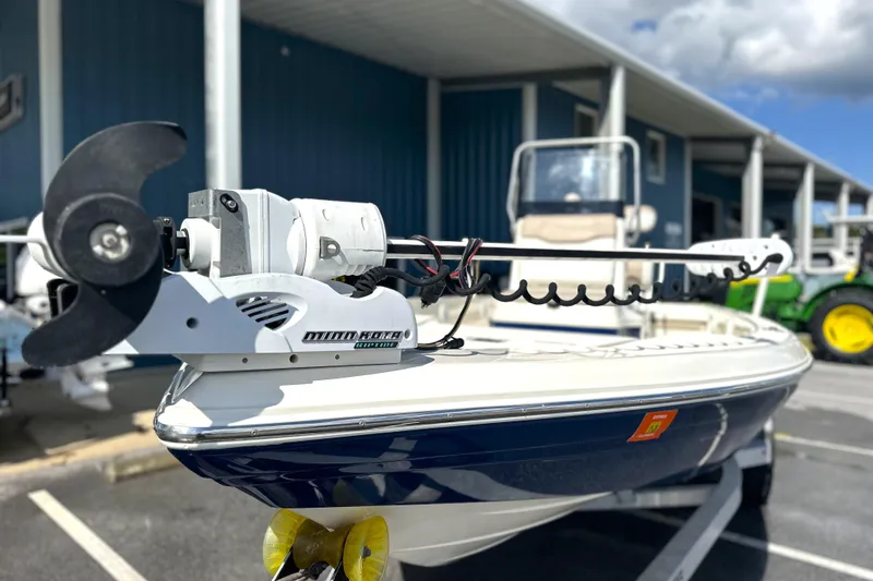 Slide: The Image of 2015 Skeeter SX220 T boat with Minn Kota trolling motor, parked outdoors. - 10