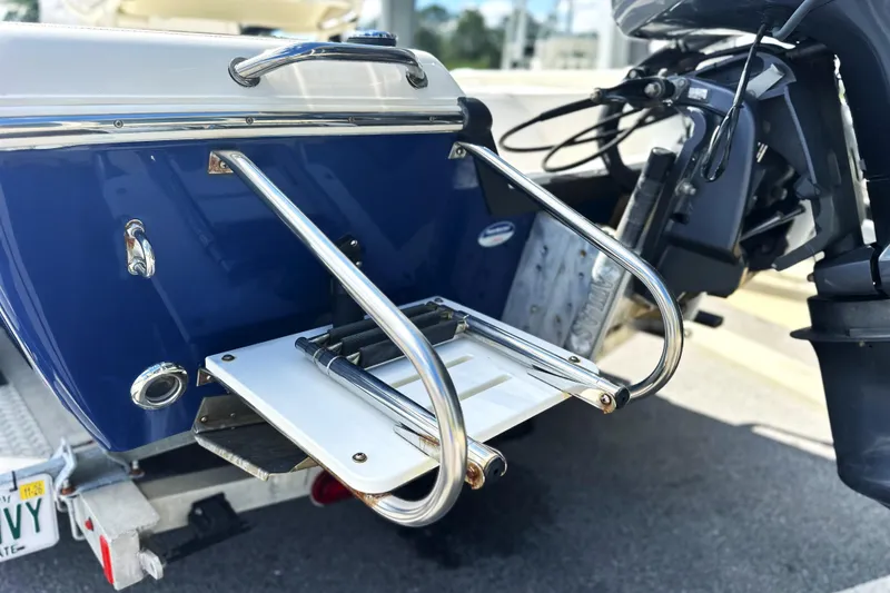 Slide: The Image of 2015 Skeeter SX220 T boat with stainless steel swim ladder and outboard motor. - 12