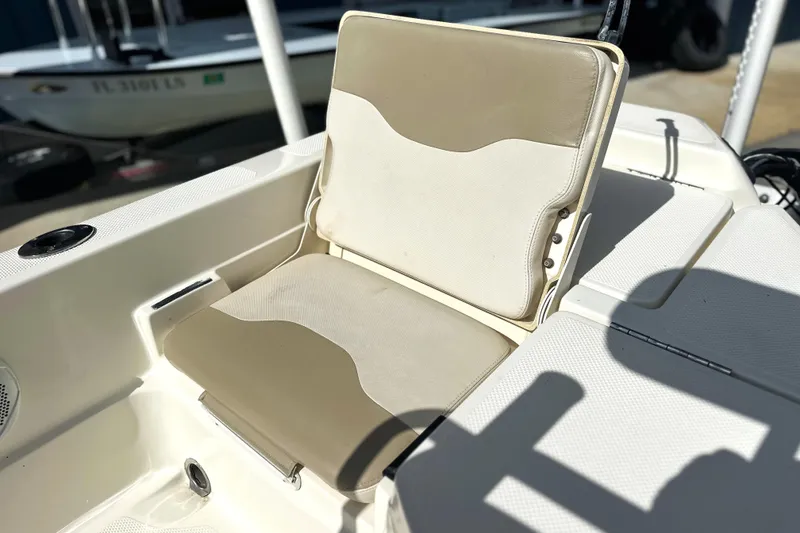 Slide: The Image of 2015 Skeeter SX220 T boat seat, beige and white, in sunlight. - 16