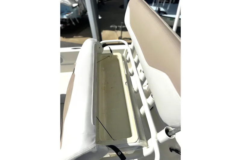 Slide: The Image of 2015 Skeeter SX220 T boat seat with storage compartment, featuring white and beige upholstery. - 19