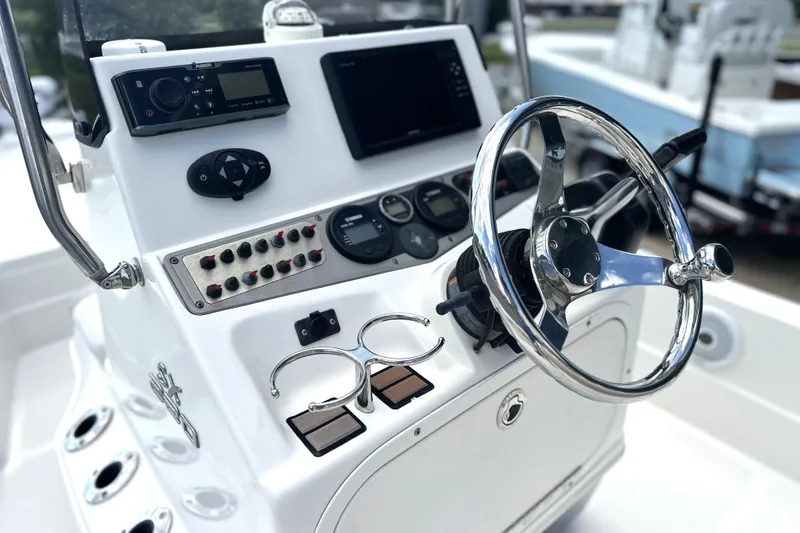 Slide: The Image of Control panel of a 2015 Skeeter SX220 T boat with steering wheel and instruments. - 22
