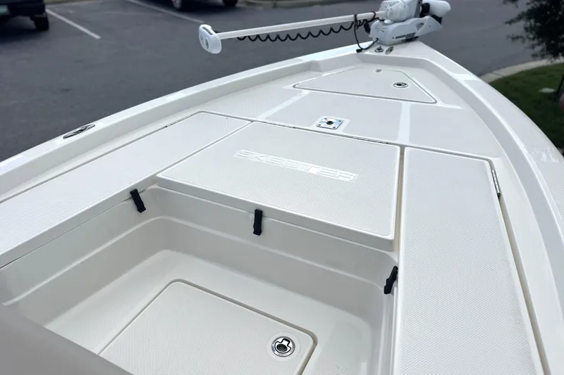 Slide: The Image of 2015 Skeeter SX220 T boat deck with storage compartments and trolling motor. - 27
