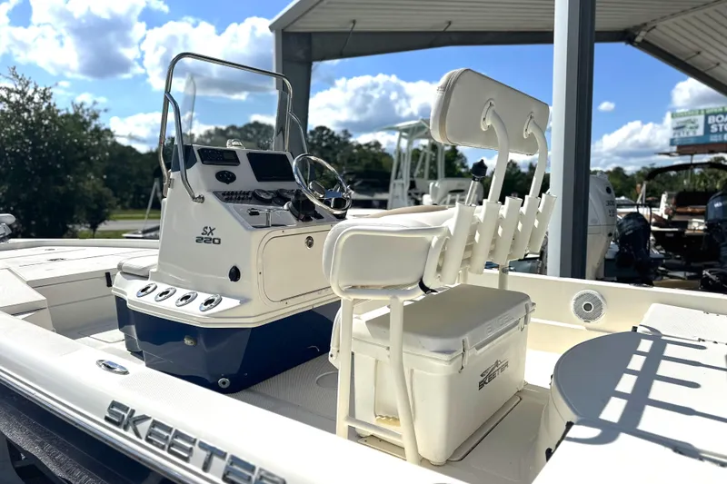 Slide: The Image of 2015 Skeeter SX220 T boat with console and seating, under a sunny sky. - 6