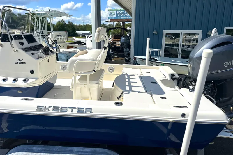 Slide: The Image of 2015 Skeeter SX220 T boat with Yamaha engine, displayed outdoors near a blue building. - 7