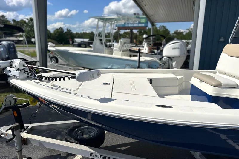 Slide: The Image of 2015 Skeeter SX220 T boat on trailer, under sunny skies at a marina. - 9