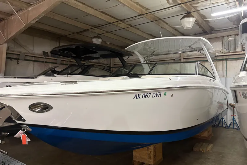 The Image of 2021 Cobalt R30 boat in storage, white hull with blue bottom, indoor warehouse setting. - 0