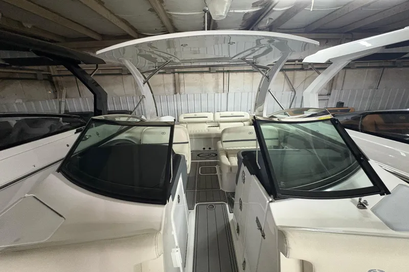 Slide: The Image of 2021 Cobalt R30 boat interior with dual windshields and spacious seating in a warehouse. - 10