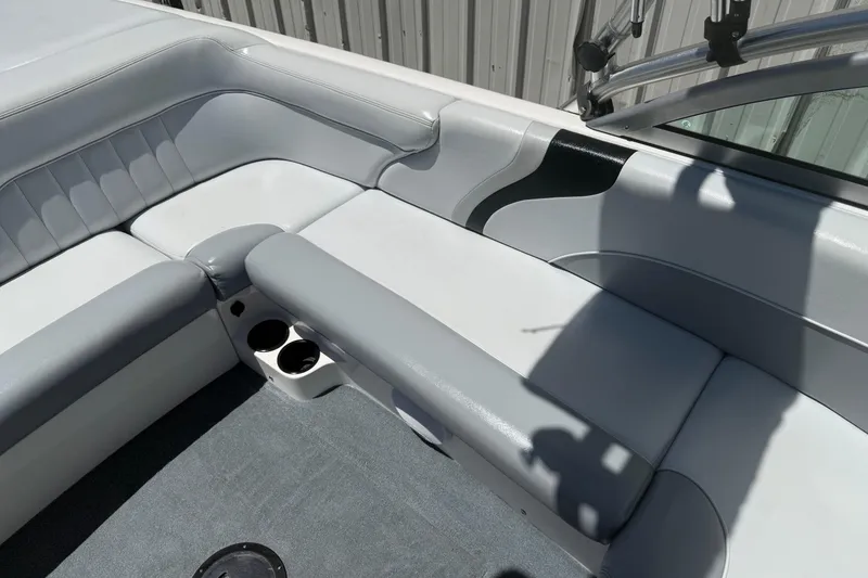 Slide: The Image of 2003 MasterCraft X2 boat interior with gray seating and cup holders. - 10