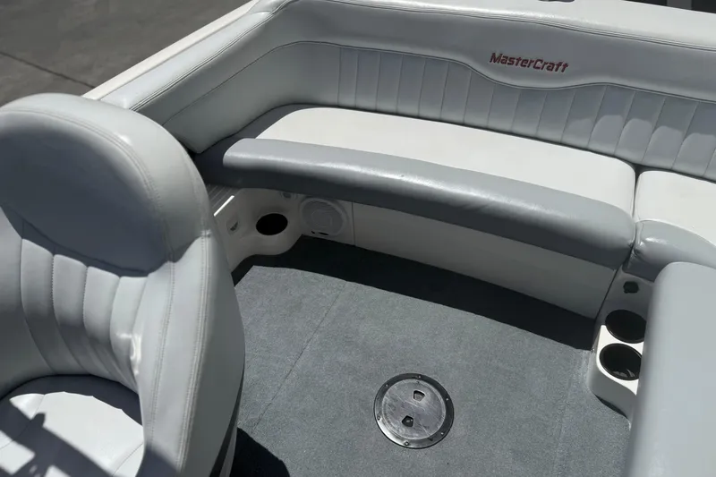 Slide: The Image of Interior of a 2003 MasterCraft X2 boat with gray seating and carpet. - 11