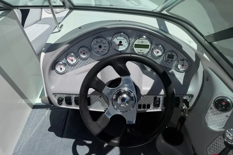 Slide: The Image of 2003 MasterCraft X2 boat dashboard with steering wheel and instrument panel. - 13