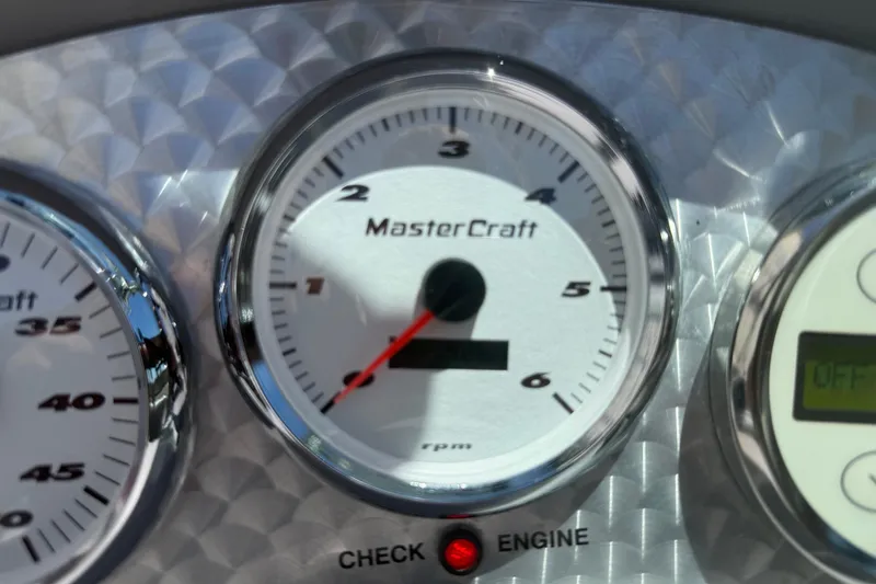 Slide: The Image of Close-up of 2003 MasterCraft X2 boat tachometer, displaying RPM gauge and engine check light. - 14