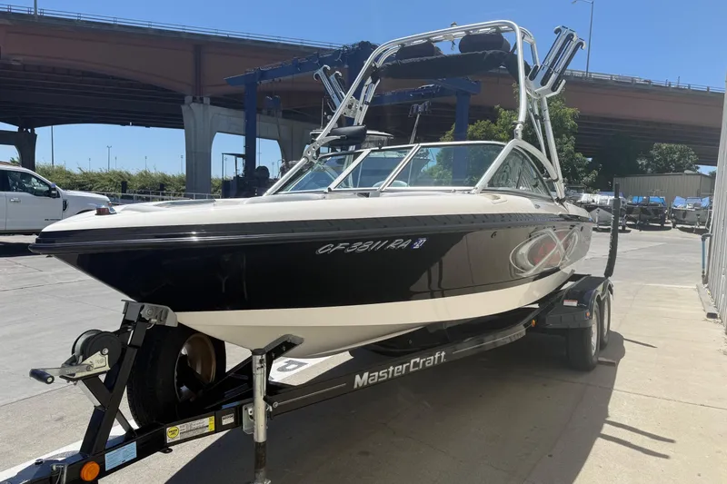 Slide: The Image of 2003 MasterCraft X2 boat on trailer under bridge, sunny day. - 2