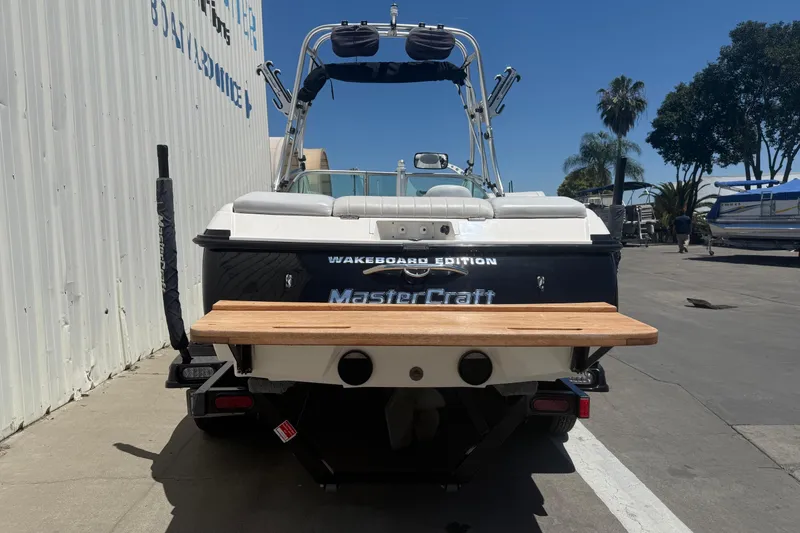 Slide: The Image of 2003 MasterCraft X2 Wakeboard Edition boat, rear view, parked outdoors. - 5