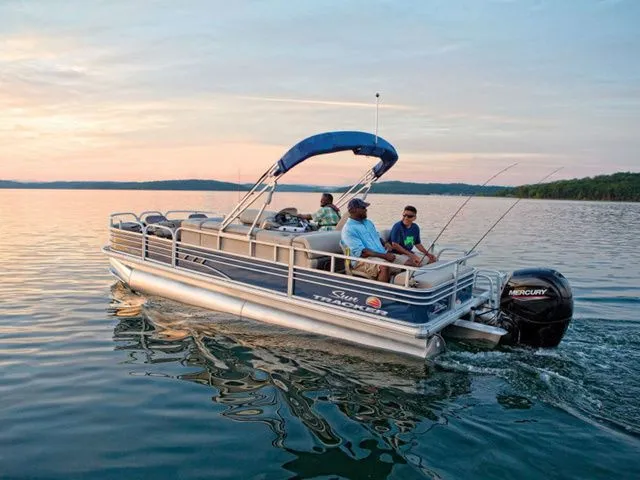 The Image of 2022 Sun Tracker Fishin' Barge 22 DLX on a serene lake at sunset. - 1