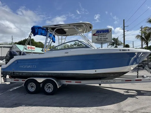 The Image of 2012 Robalo 247 DC boat on trailer, blue hull. - 1
