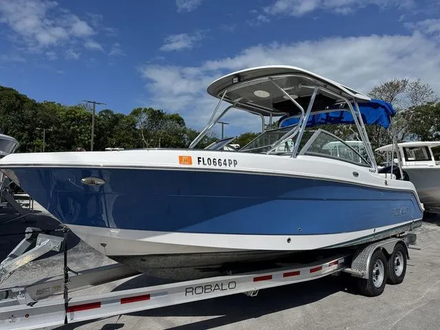 Slide: The Image of 2012 Robalo 247 DC boat on trailer, blue hull, sunny day. - 3