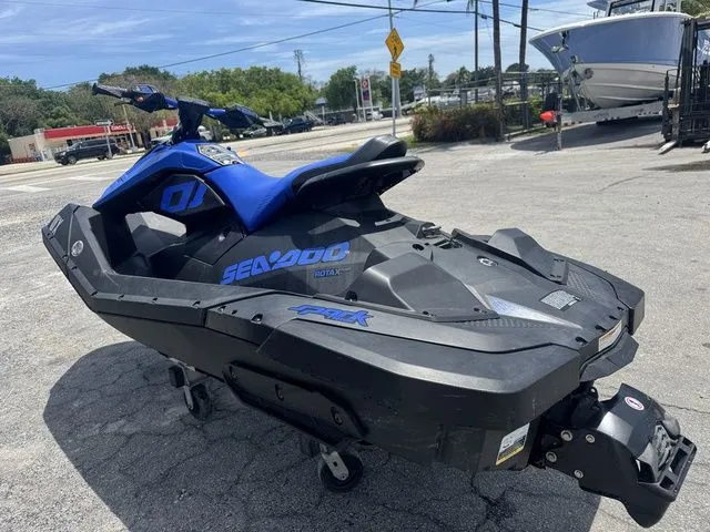 Slide: The Image of 2023 Sea-Doo Spark Trixx jet ski in blue and black on a parking lot. - 7