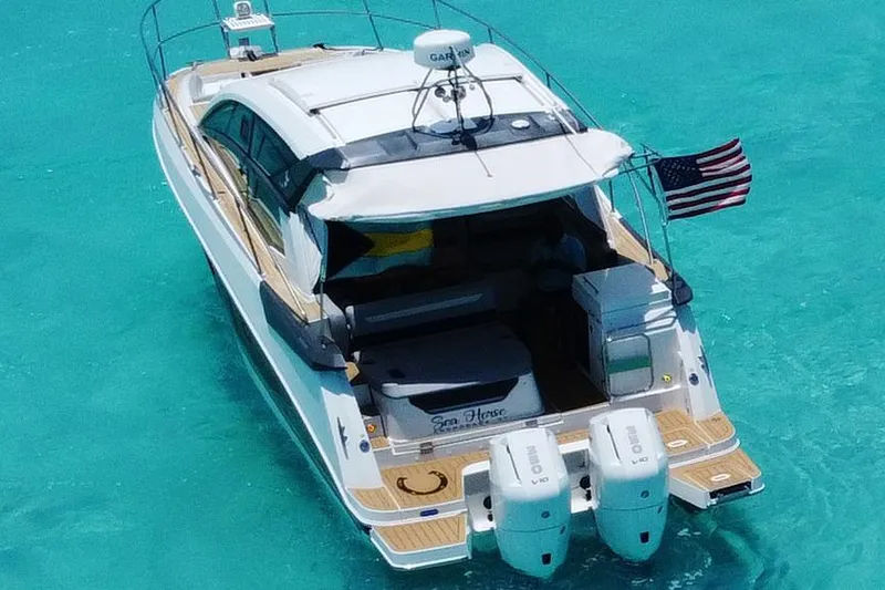 Slide: The Image of 2024 Beneteau Gran Turismo 36 yacht on turquoise water, rear view with American flag. - 2