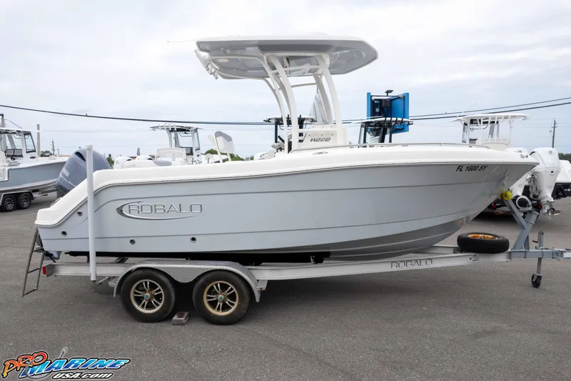 Slide: The Image of 2021 Robalo R222 Center Console boat on trailer, side view, in a marina setting. - 17