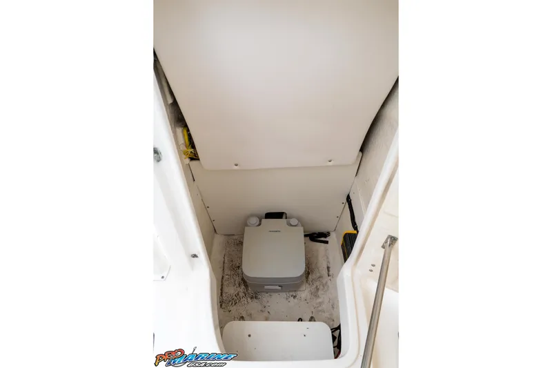 Slide: The Image of 2021 Robalo R222 Center Console boat interior with portable toilet. - 24