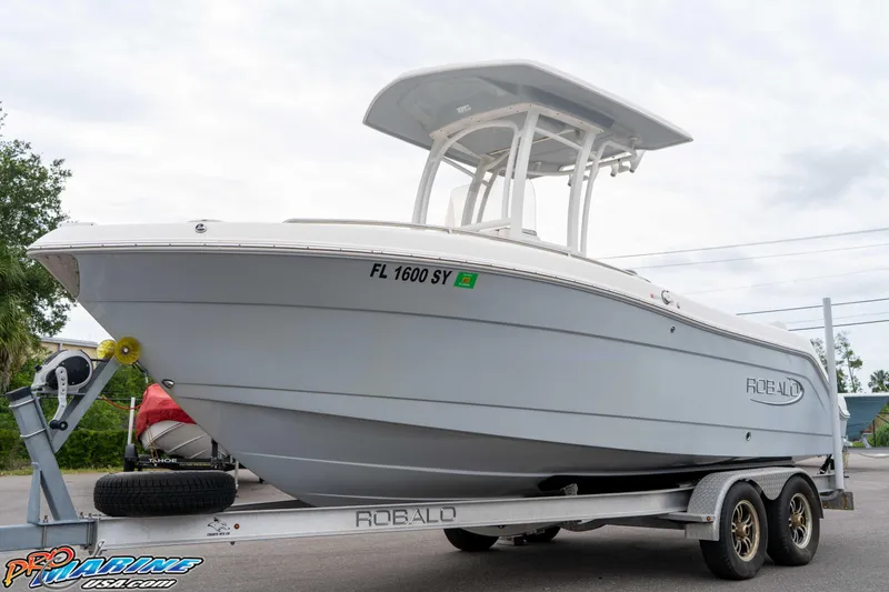 Slide: The Image of 2021 Robalo R222 Center Console boat on trailer, displayed outdoors. - 30