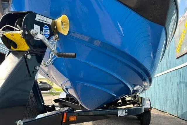 Slide: The Image of Blue 2016 Yamaha Boats 212X on trailer, close-up view of hull and winch. - 2