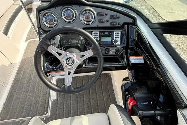 Slide: The Image of Cockpit view of 2016 Yamaha Boats 212X, featuring steering wheel and dashboard controls. - 22