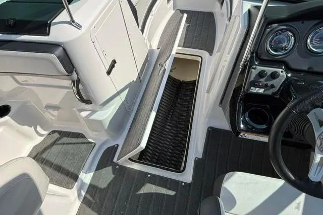 Slide: The Image of 2016 Yamaha Boats 212X interior with open storage compartment and dashboard view. - 25
