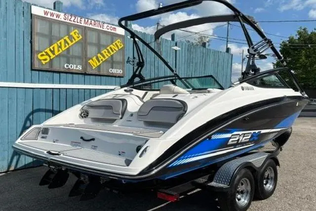 Slide: The Image of 2016 Yamaha Boats 212X on trailer at Sizzle Marine dealership, blue and white design. - 3