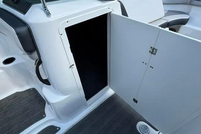 Slide: The Image of 2016 Yamaha Boats 212X interior storage compartment with open door, showcasing sleek design and functionality. - 33