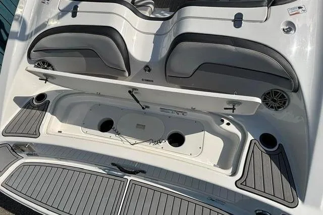 Slide: The Image of 2016 Yamaha Boats 212X rear seating and storage area with open compartments. - 34