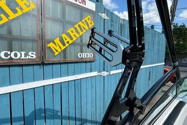 Slide: The Image of 2016 Yamaha Boats 212X near blue fence with marine signage. - 35