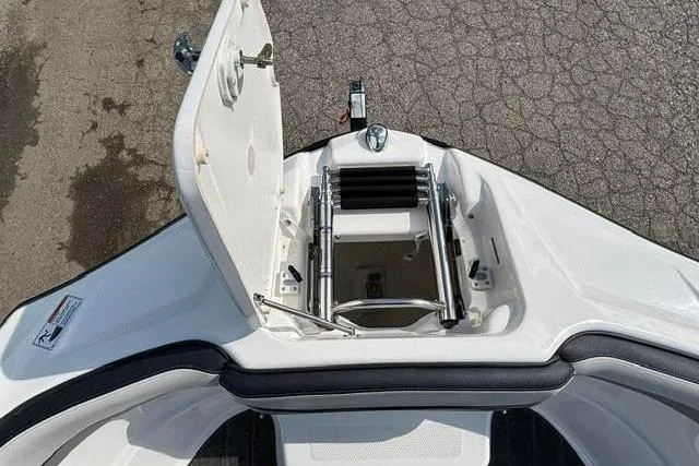 Slide: The Image of 2016 Yamaha Boats 212X bow storage compartment with ladder, open on a textured surface. - 8