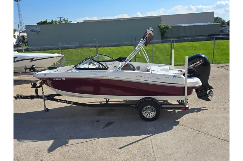 The Image of 2020 Tahoe 500 TF boat on trailer, maroon and white, with Mercury outboard motor. - 0