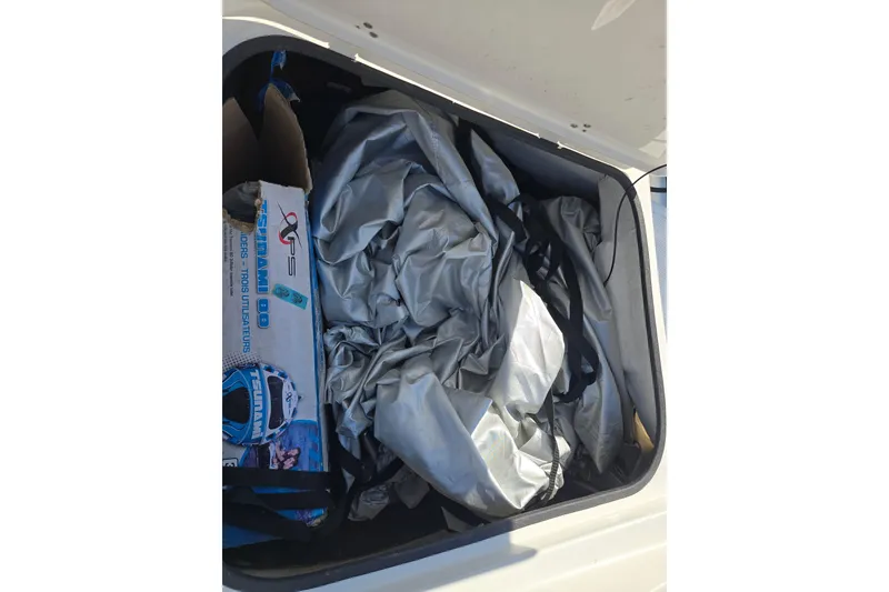 Slide: The Image of Storage compartment of a 2020 Tahoe 500 TF boat with folded tarp and box. - 15
