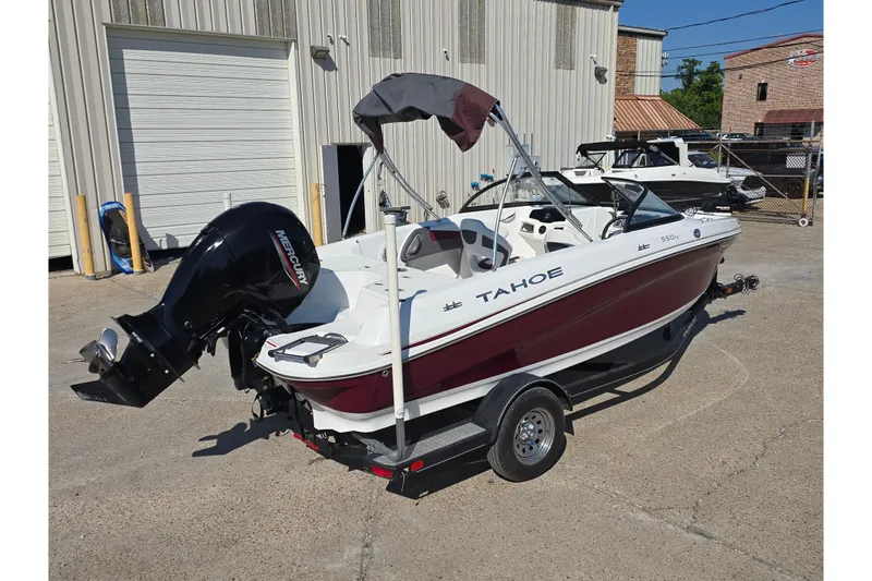 Slide: The Image of 2020 Tahoe 500 TF boat with Mercury engine on trailer, parked outside a warehouse. - 2