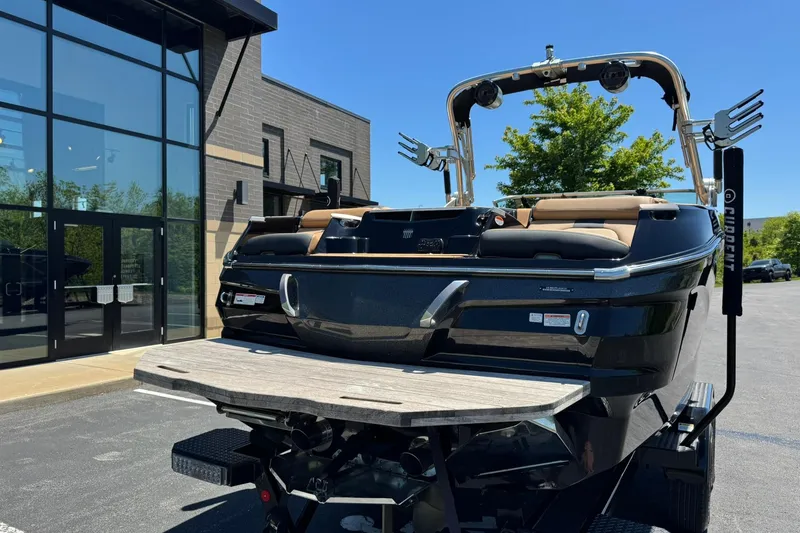 Slide: The Image of 2021 MasterCraft X26 boat on trailer, parked outside modern building. - 3