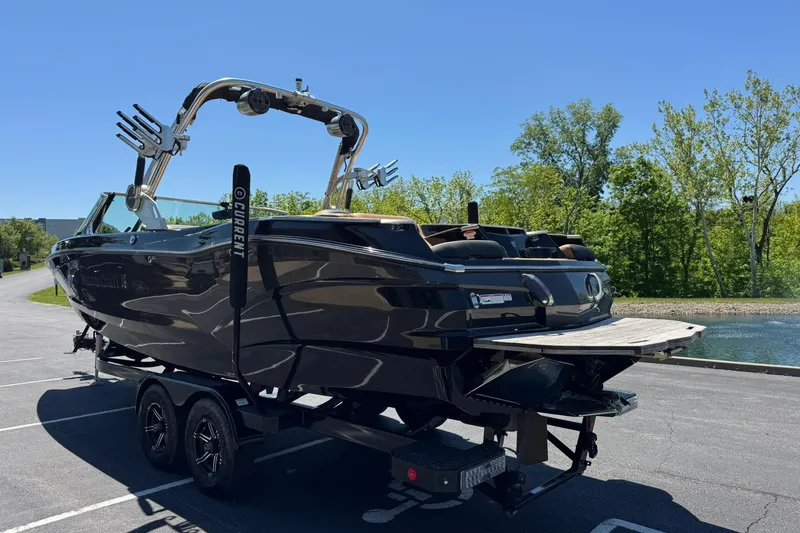 Slide: The Image of 2021 MasterCraft X26 boat on trailer, parked near a scenic lake. - 4