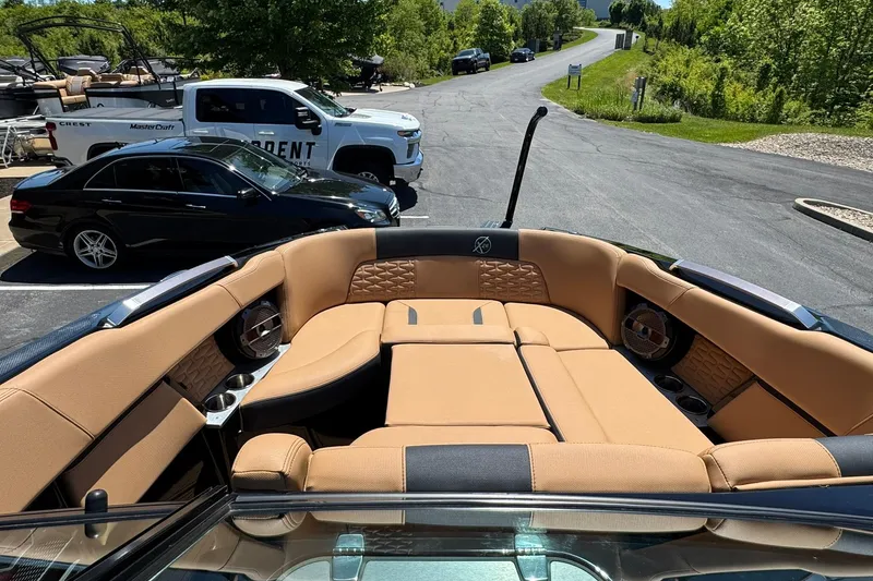 Slide: The Image of 2021 MasterCraft X26 boat interior with tan seating and cup holders. - 7