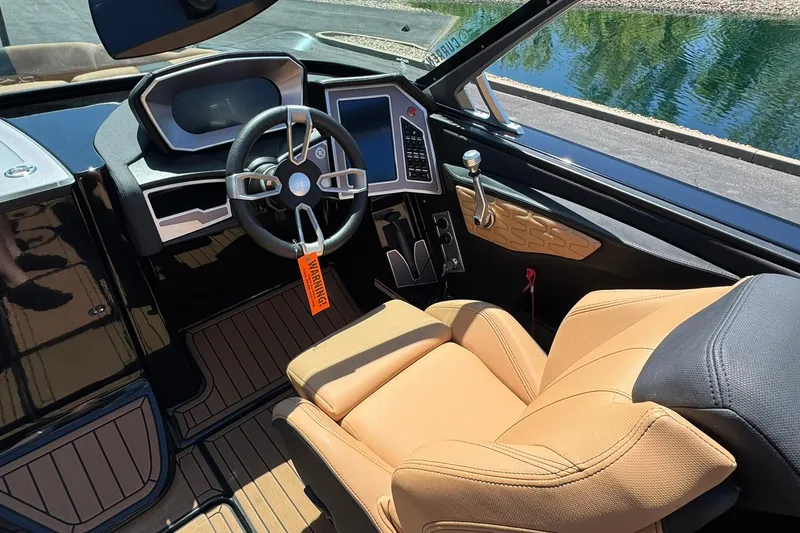 Slide: The Image of 2021 MasterCraft X26 boat interior with tan seats and modern dashboard controls. - 8