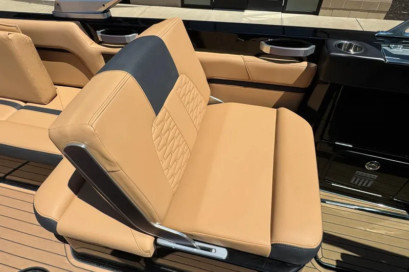 Slide: The Image of Luxurious tan seating on 2021 MasterCraft X26 boat, featuring sleek design and cup holders. - 9