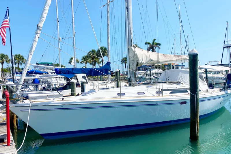 Slide: The Image of 2004 Catalina 42 MkII sailboat docked in a sunny marina with palm trees. - 5
