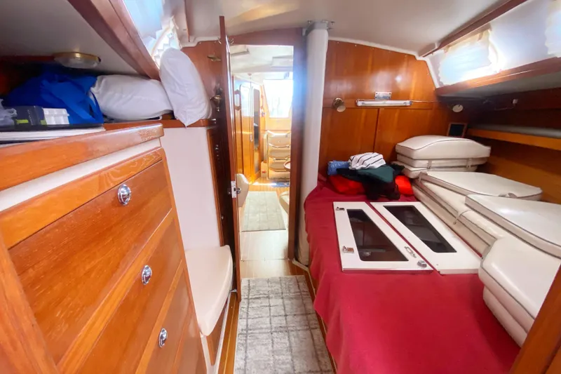 Slide: The Image of Interior of a 2004 Catalina 42 MkII sailboat, featuring cozy wooden cabinetry and a comfortable berth. - 30