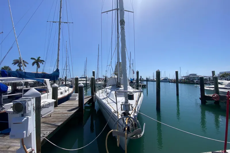 Slide: The Image of 2004 Catalina 42 MkII sailboat docked in a sunny marina with clear blue skies. - 7