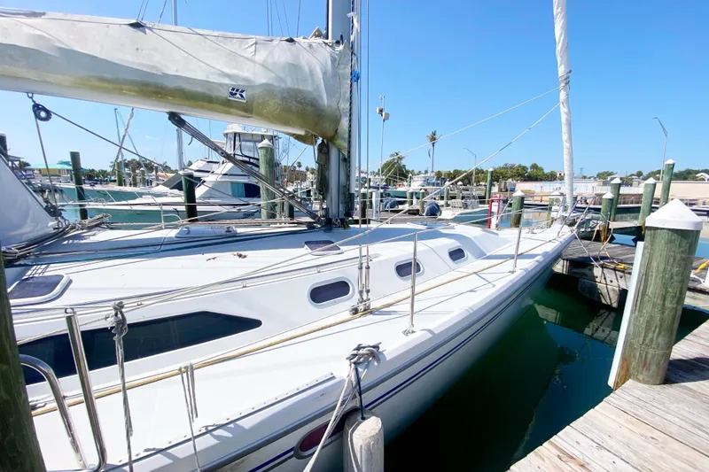 Slide: The Image of 2004 Catalina 42 MkII sailboat docked at a marina under clear blue skies. - 8