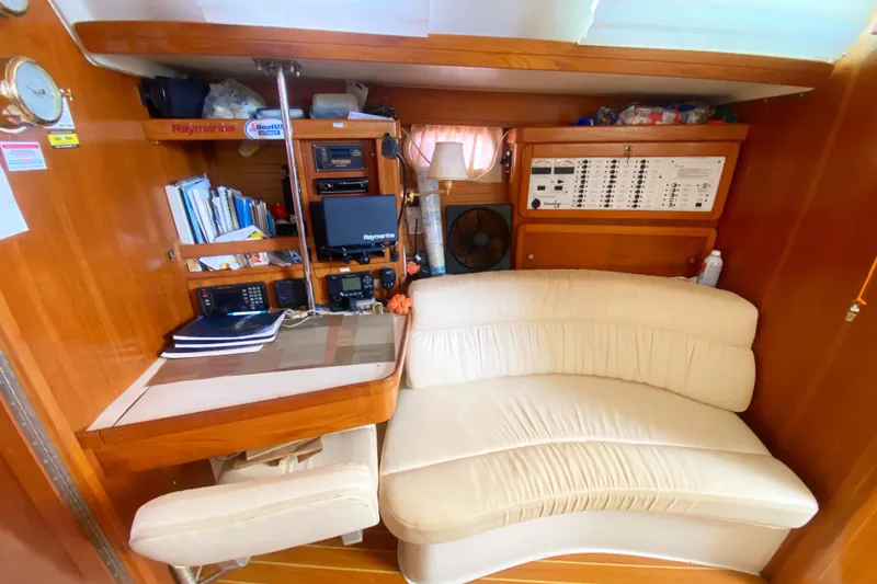 Slide: The Image of Interior of 2004 Catalina 42 MkII yacht with navigation station and cream seating. - 28
